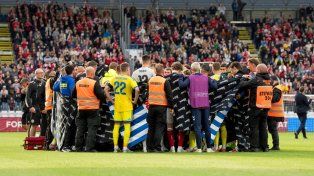 Ambos planteles rodean a Eriksen tras desplomarse en el campo de juego.