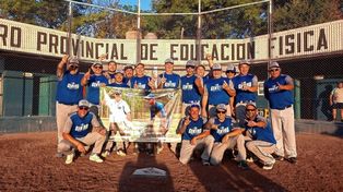 El equipo de Lanzamiento Lento de sóftbol junto a la bandera recordando a dos amigos.