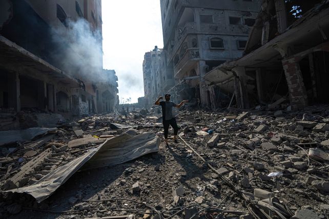 Un palestino camina en un barrio de Gaza atacado por las bombas. Hamás respondió con cohetes.