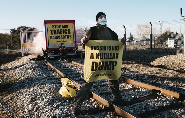 Un activista de Greenpeace sostiene una pancarta durante un intento de bloquear un convoy de desechos nucleares franceses que se dirigía a Rusia en Pierrelate