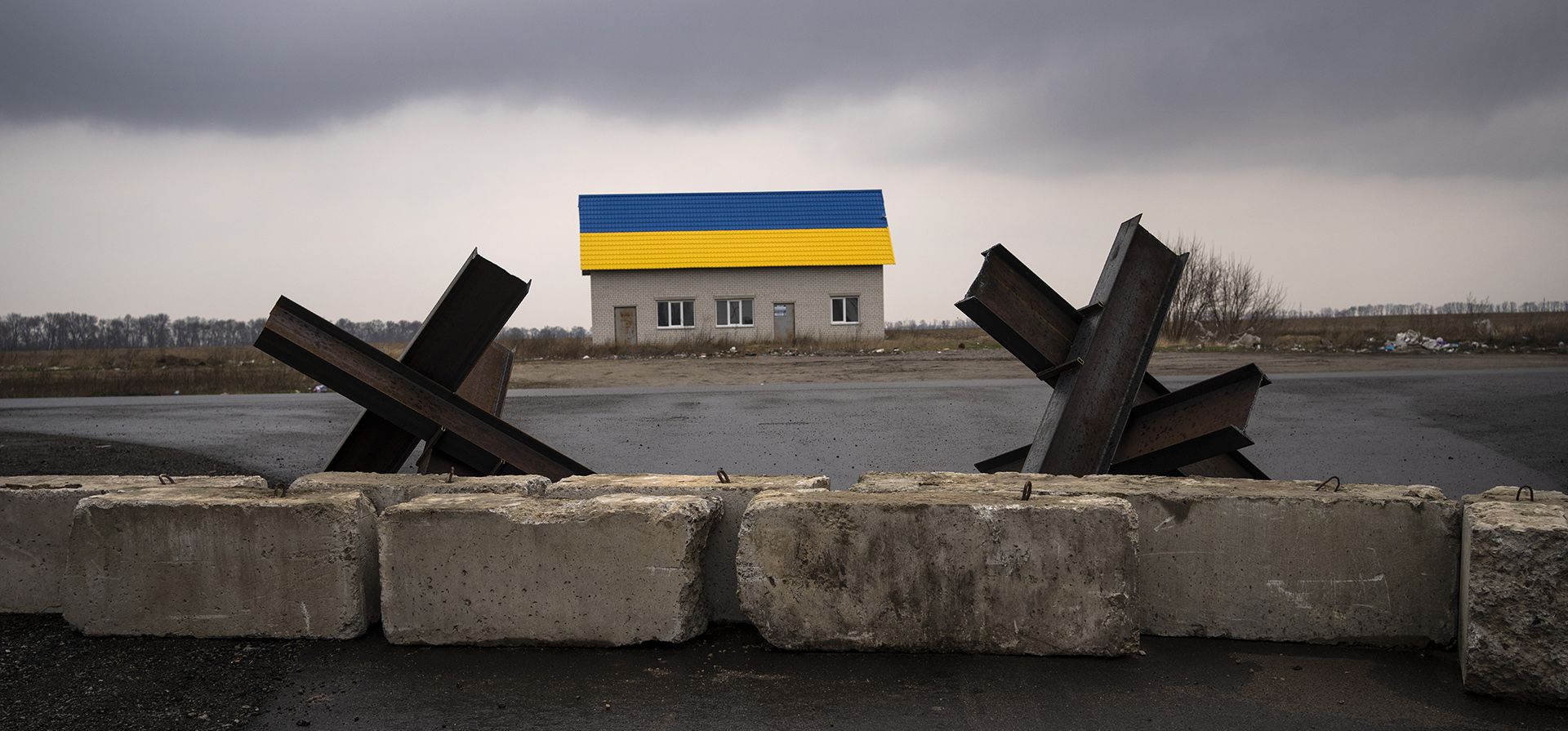 Barreras antitanques colocadas cerca de una casa pintada con los colores de la bandera de Ucrania cerca del pueblo de Malaya Alexandrovka, en las afueras de Kiev, Ucrania, el miércoles 30 de marzo de 2022.