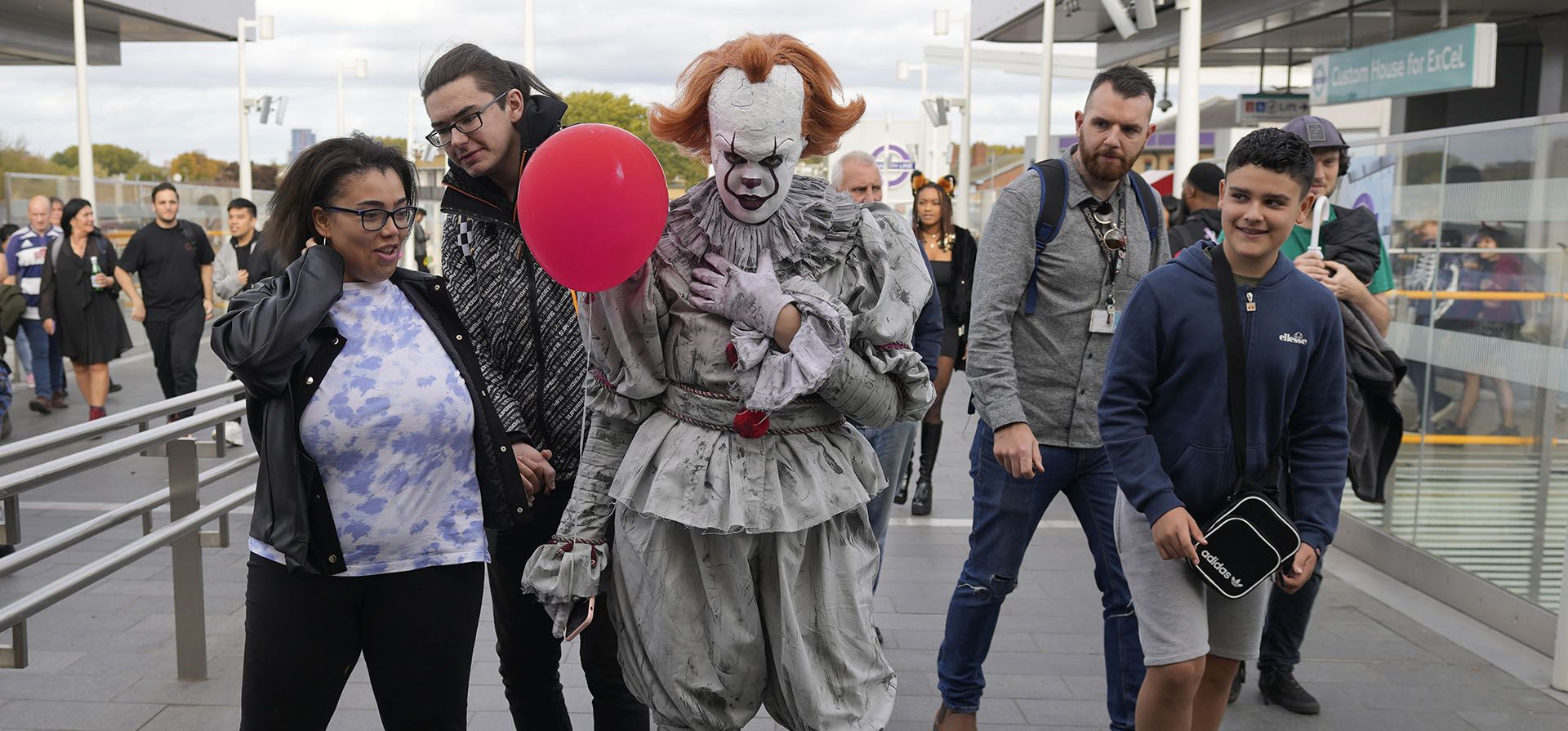 Una persona vestida como Pennywise del libro de terror IT de Stephen King, mientras personajes de cómics de superhéroes, videojuegos y películas de culto posan para retratos en el primer día de la convención ComicCon en el Centro ExCel de Londres, el viernes 28 de octubre de 2022.