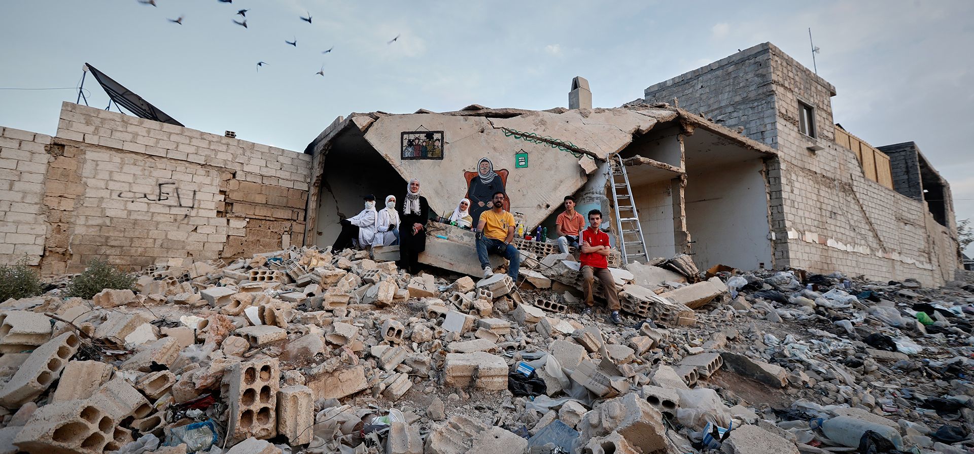 Un grupo de artistas callejeros sirios posan para una foto después de pintar un mural en el techo derrumbado de una casa dañada por la guerra en Daraya, en las afueras de Damasco, Siria, el lunes 3 de noviembre de 2025. (Foto AP/Omar Sanadiki) Un grupo de artistas callejeros sirios posan para una foto después de pintar un mural en el techo derrumbado de una casa dañada por la guerra en Daraya, en las afueras de Damasco, Siria, el lunes 3 de noviembre de 2025. (Foto AP/Omar Sanadiki)