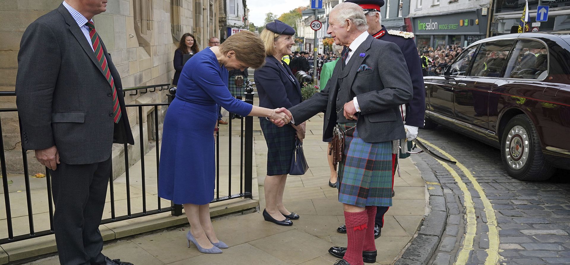 El rey Carlos III de Gran Bretaña le da la mano a la primera ministra escocesa Nicola Sturgeon, cuando llega a las Cámaras de la ciudad en Dunfermline, Fife, para marcar formalmente la concesión del estatus de ciudad a la antigua ciudad.