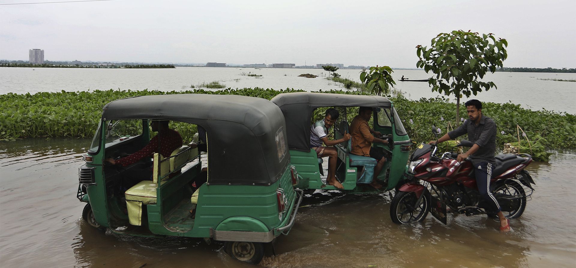 Vehículos rickshaws circulan por una carretera inundada en el área de Bagha en Sylhet, Bangladesh, el lunes 23 de mayo de 2022. Las inundaciones previas al monzón han inundado partes de India y Bangladesh.