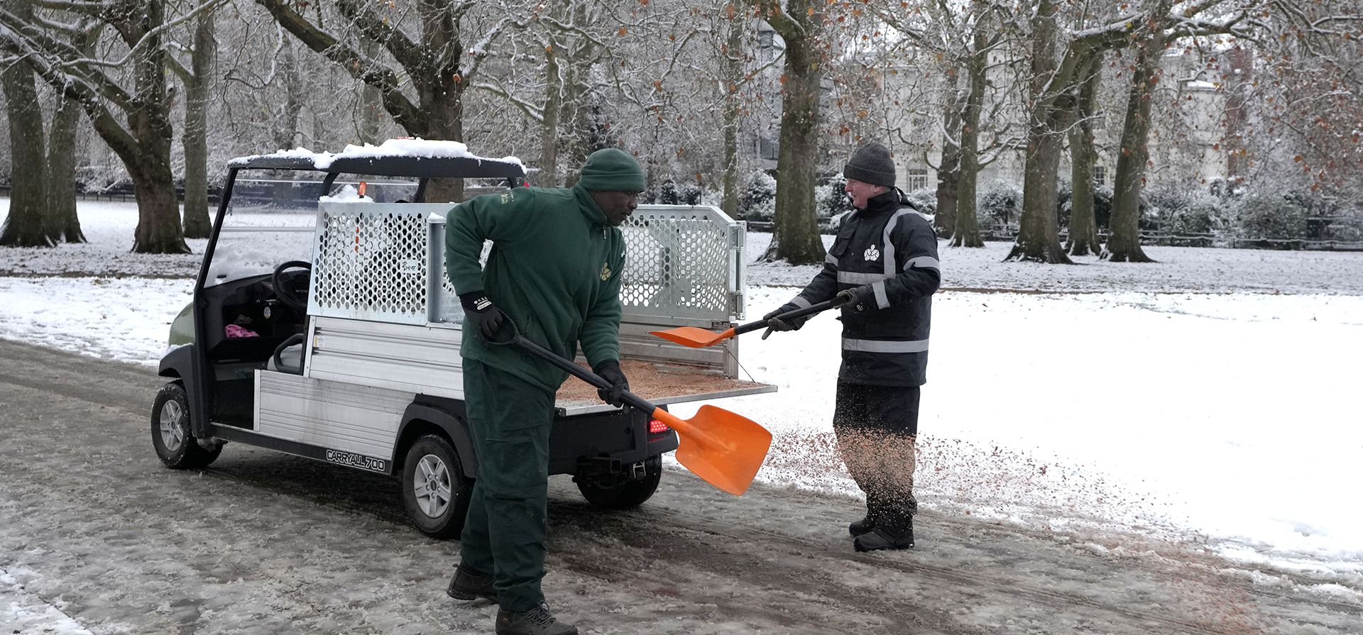 Trabajadores de limpieza esparcen arena en Green Park en Londres, el lunes 12 de diciembre de 2022. La nieve y el hielo han barrido partes del Reino Unido, con condiciones invernales frías que continuarán durante días. (Foto AP/Kirsty Wigglesworth)