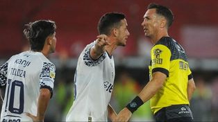 Pablo Dóvalo recibe los cuestionamientos de algunos jugadores de Independiente en el polémico cotejo ante Barracas Central.