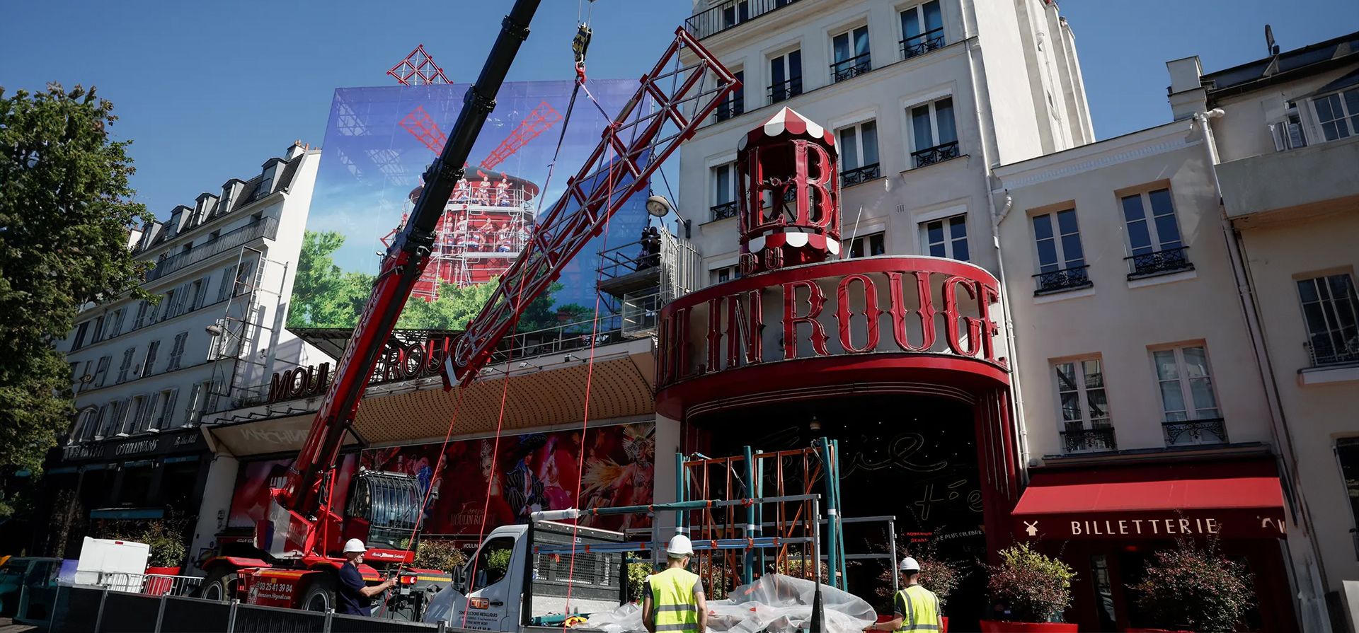 Una grúa levanta una de las cuatro nuevas velas de molino de viento que se instalarán en el Moulin Rouge, el club de cabaret más famoso de París, después de que sus velas se cayeran en abril, París, Francia. Fotografía: Benoît Tessier/Reuters Una grúa levanta una de las cuatro nuevas velas de molino de viento que se instalarán en el Moulin Rouge, el club de cabaret más famoso de París, después de que sus velas se cayeran en abril, París, Francia. Fotografía: Benoît Tessier/Reuters