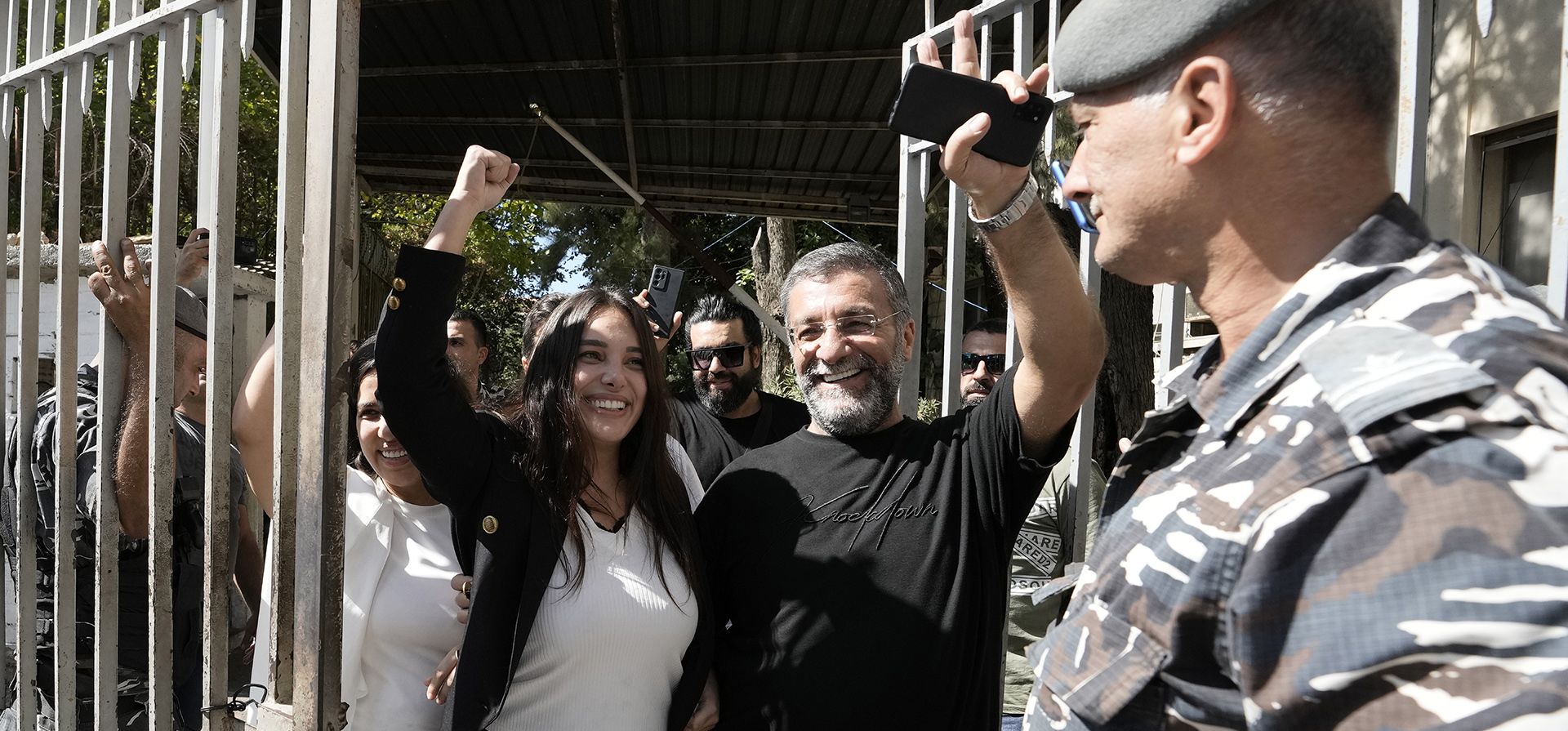 Sali Hafez, a la izquierda, quien irrumpió en una sucursal del Banco BLOM el mes pasado con otros activistas y obligó a los empleados del banco a entregar $12,000 y el equivalente a unos $1,000 en libras libanesas hace gestos cuando sale del Palacio de Justicia, en Beirut, Líbano. Un juez libanés multó y emitió una prohibición de viaje de seis meses a Hafez, quien irrumpió en su banco con una pistola falsa y tomó sus ahorros atrapados para cubrir el tratamiento del cáncer de su hermana.