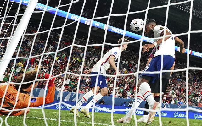 El estadounidense Jordan Siebatcheu Pefok (16) intenta cabecear el balón a la red contra el mexicano Guillermo Ochoa (13) durante el partido de fútbol por el campeonato de la Liga de Naciones de la CONCACAF