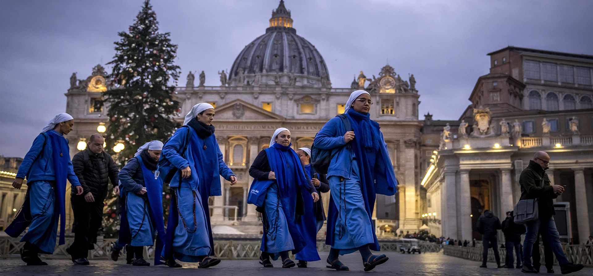 Un grupo de monjas llegan al amanecer para ver el cuerpo del papa emérito Benedicto XVI en la Basílica de San Pedro en el Vaticano, el martes 3 de enero de 2023. (AP Photo/Ben Curtis)