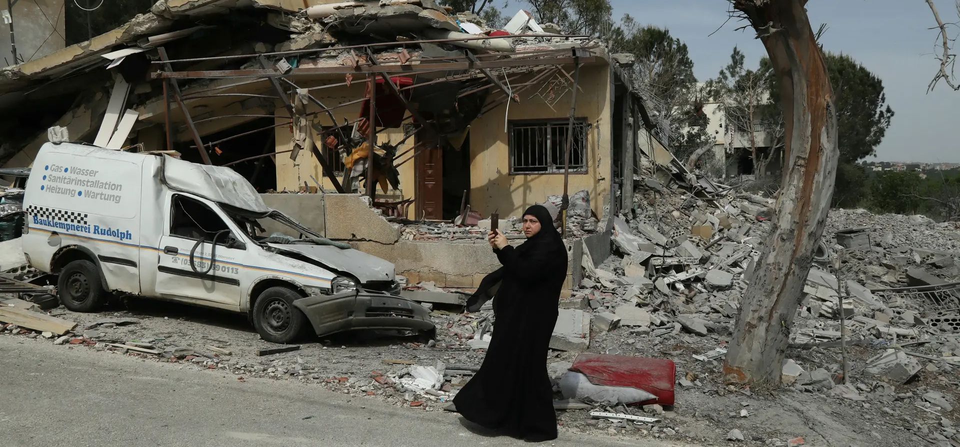 Una mujer frente a una casa en la que dos mujeres de la misma familia murieron el 23 de abril en un ataque israelí, Hanin, Líbano. Fotografía: Hassan Fneich/AFP/Getty Images