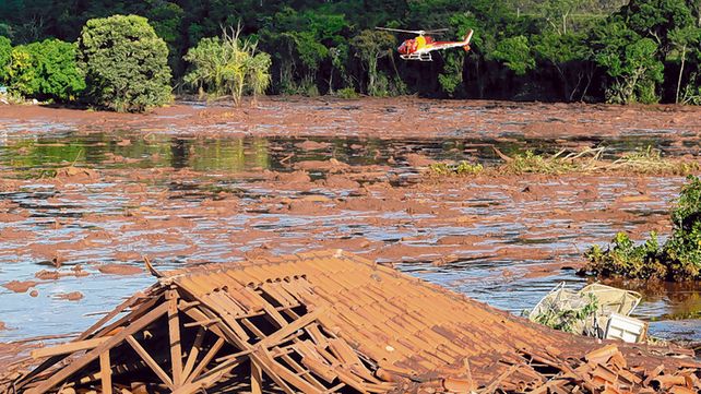Marea de barro. Un helicóptero busca posibles sobrevivientes en la zona afectada por el derrame de lodo.