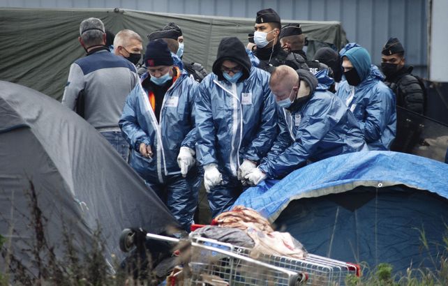 Las fuerzas policiales abren carpas de los migrantes evacuados de un campamento en Grande-Synthe