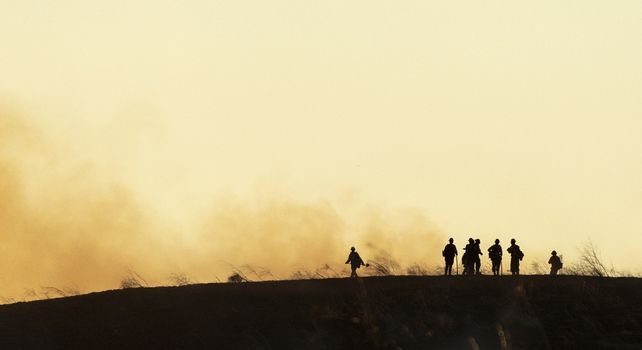Un equipo de rescate observa desde una colina la devastación provocada por las llamas. 
