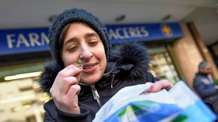 Una joven muestra y a la vez percibe los gramos de cannabis a la salida de una farmacia de Montevideo.