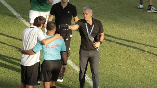 Pablo Lavallén le muestra su teléfono al árbitro. El director técnico argentino estalló contra el fútbol de Honduras.