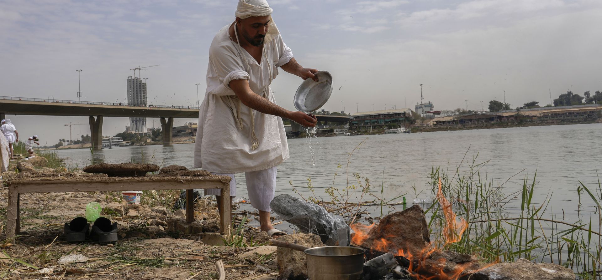 Un miembro de los sabeos mandeos, una secta precristiana que sigue las enseñanzas de Juan el Bautista, se prepara para comer cerca de la orilla del río Tigris en Bagdad, Irak, el martes 15 de marzo de 2022. Los sabeos iraquíes mandeos ven a Juan el Bautista. Bautista como su profeta central y se sumergen en el Tigris durante un ritual anual de cinco días.