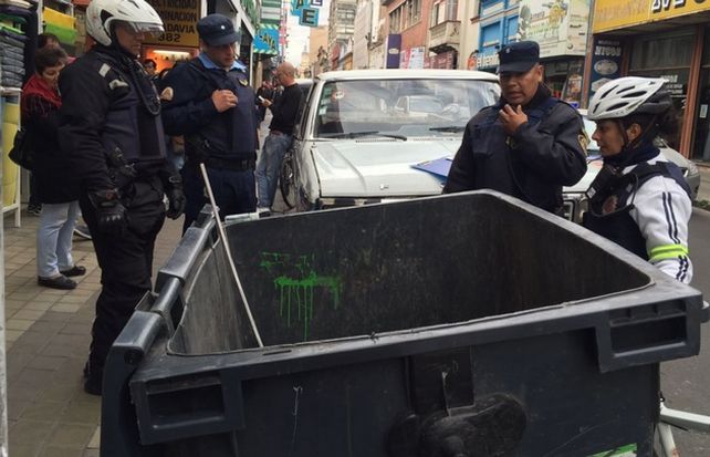 Pleno centro de la ciudad de Córdoba. Policías examinan el contenedor donde apareció la criatura.&nbsp;