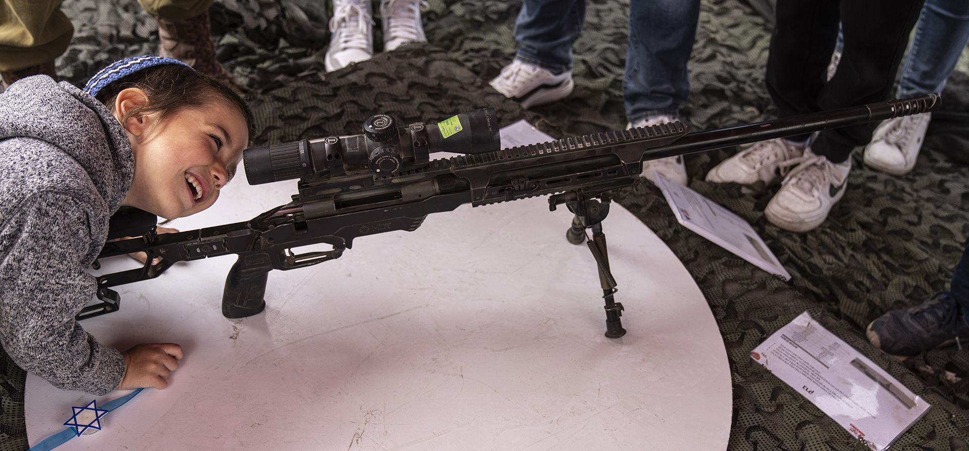 Un niño israelí examina un rifle de francotirador en una exhibición de armas del ejército durante las celebraciones del 74º Día de la Independencia de Israel, en el Parque Industrial Gush Etzion en Cisjordania, el jueves 5 de mayo de 2022.