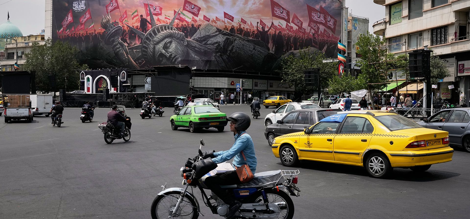 Vehículos circulan frente a una valla publicitaria que muestra una Estatua de la Libertad caída y multitudes que portan banderas iraníes y chiítas en la Plaza de la Revolución en Teherán, Irán, el lunes 3 de agosto de 2026. (Foto AP/Vahid Salemi) Vehículos circulan frente a una valla publicitaria que muestra una Estatua de la Libertad caída y multitudes que portan banderas iraníes y chiítas en la Plaza de la Revolución en Teherán, Irán, el lunes 3 de agosto de 2026. (Foto AP/Vahid Salemi)