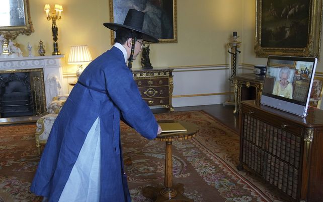 Queen Isabel II aparece en una pantalla a través de un enlace de video desde el Castillo de Windsor
