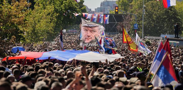 Personas reunidas para la procesión fúnebre ondean una bandera con la imagen del excomandante del ejército serbobosnio Ratko Mladic