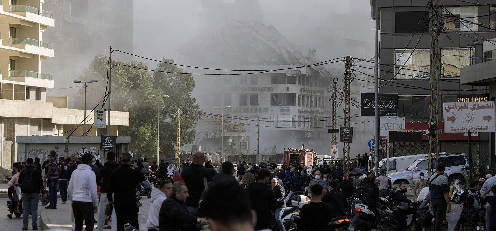 La gente observa cómo sale humo de un edificio que se derrumba tras un ataque aéreo israelí en Chiyah, en el suburbio sur de Beirut, Líbano, el viernes 22 de noviembre de 2024. (Foto AP/Bilal Hussein)