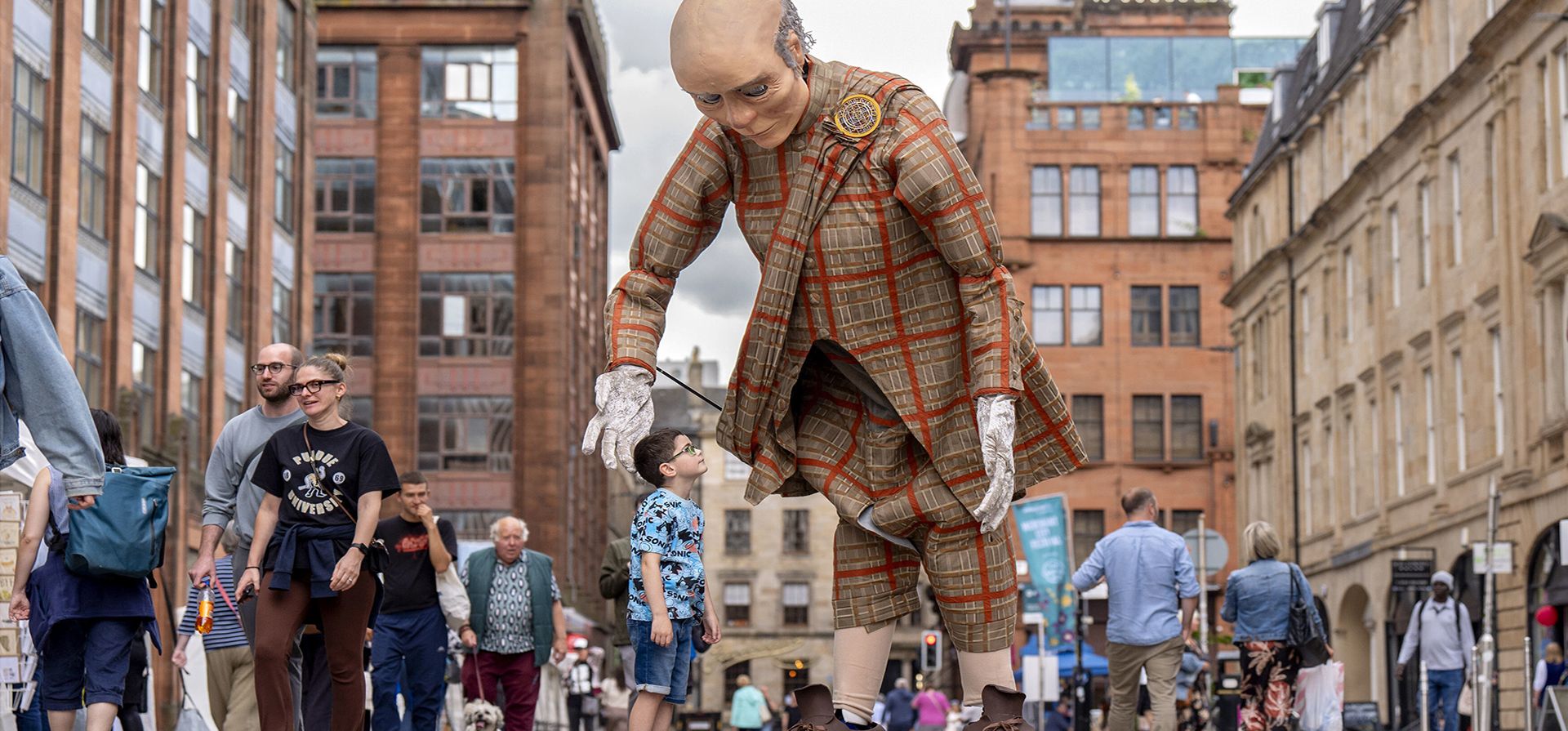 Un niño, de Southside, Glasgow, conoce a 'Poet', uno de los títeres gigantes de Bridgeman Arts, que entretuvieron a la multitud el primer día del Merchant City Festival en Glasgow, Escocia, el viernes 18 de julio de 2025. (Jane Barlow/PA vía AP) Un niño, de Southside, Glasgow, conoce a 'Poet', uno de los títeres gigantes de Bridgeman Arts, que entretuvieron a la multitud el primer día del Merchant City Festival en Glasgow, Escocia, el viernes 18 de julio de 2025. (Jane Barlow/PA vía AP)