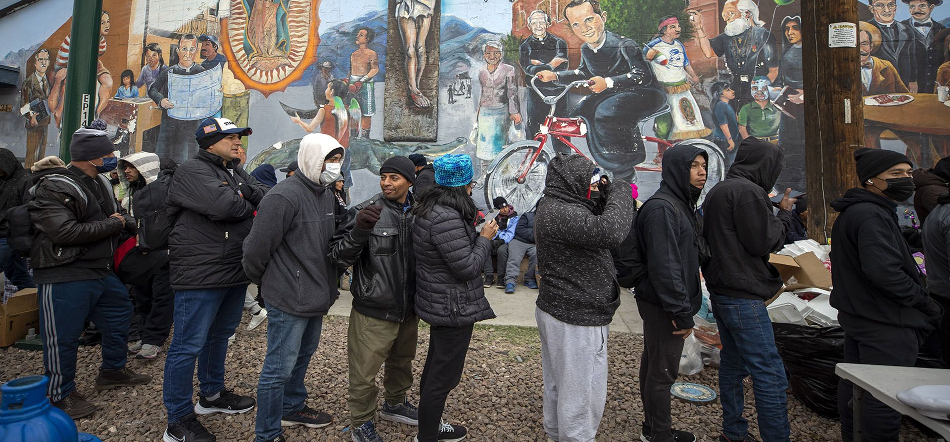Migrantes forman una fila para recibir alimentos calientes donados por los residentes en el centro de El Paso, Texas, el domingo 18 de diciembre de 2022. (Foto AP/Andrés Leighton)