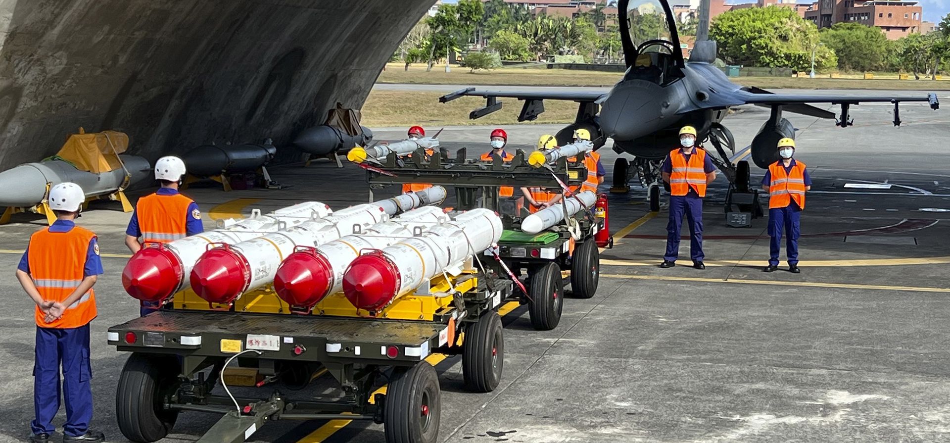 Personal militar de pie junto a Harpoon A-84, misiles antibuque y misiles aire-aire AIM-120 y AIM-9 preparados para un simulacro de carga de armas frente a un avión de combate F16V en la base aérea de Hualien en el condado de Hualien en el sureste de Taiwán el miércoles, 17 de agosto de 2022.