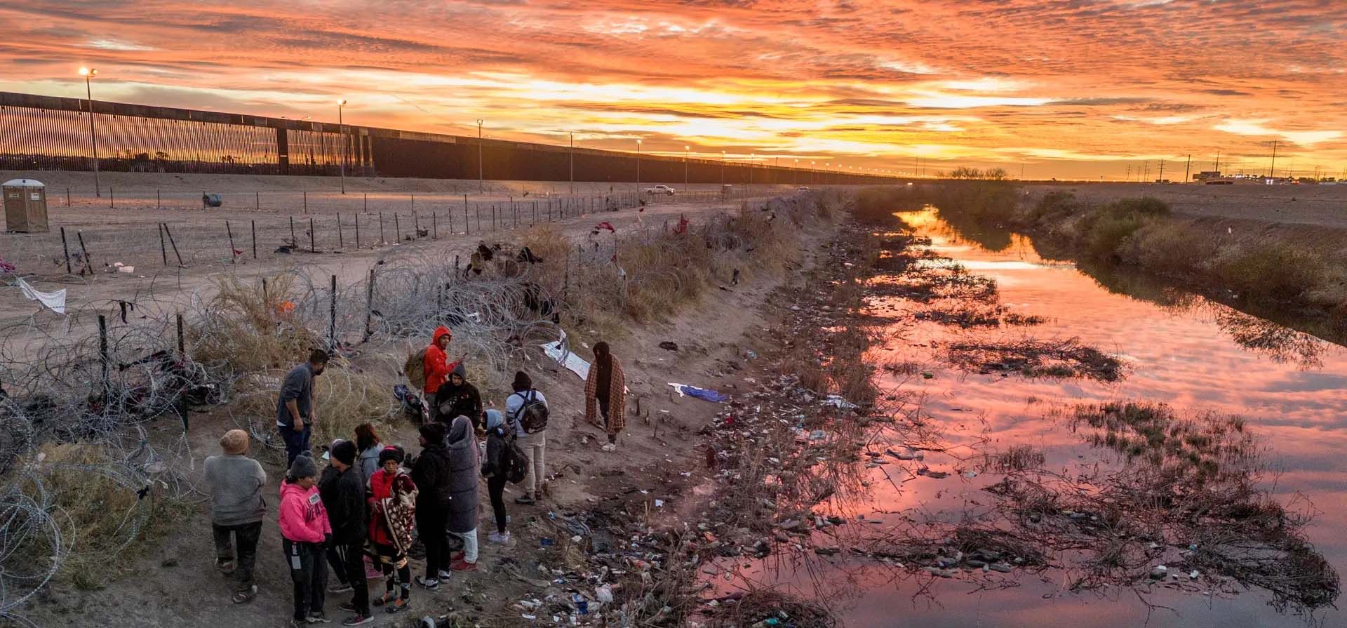 La gente espera junto al alambre de púas después de cruzar el río Bravo. Aquellos que logran atravesar el cable pueden proceder a ser procesados por un agente de la Patrulla Fronteriza de EE. UU, El Paso, Texas, Estados Unidos. Fotografía: John Moore/Getty Images La gente espera junto al alambre de púas después de cruzar el río Bravo. Aquellos que logran atravesar el cable pueden proceder a ser procesados por un agente de la Patrulla Fronteriza de EE. UU, El Paso, Texas, Estados Unidos. Fotografía: John Moore/Getty Images