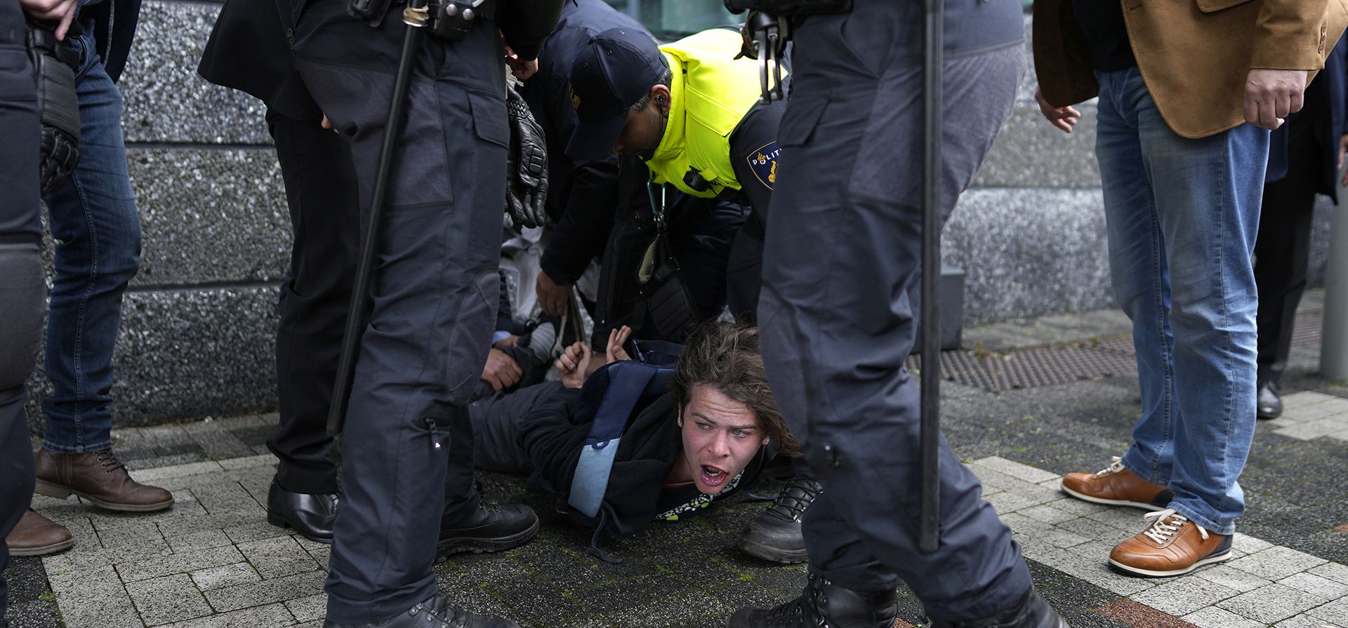 Un manifestante es detenido por agentes de policía cuando el presidente francés Emmanuel Macron y el rey holandés Willem-Alexander llegan a la facultad de ciencias de la UvA, Universidad de Ámsterdam, Países Bajos, el miércoles 12 de abril de 2023. (Foto AP/Peter Dejong)