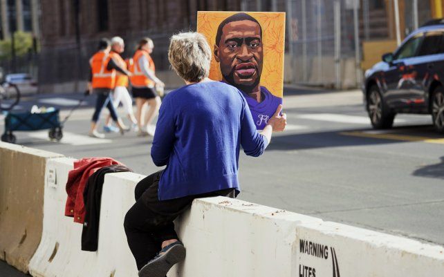 Una mujer sostiene una foto de George Floyd cerca del Centro de Gobierno del Condado de Hennepin, en Minneapolis, en la segunda semana de testimonios en el juicio del ex oficial de policía de Minneapolis Derek Chauvin, acusado de asesinato por la muerte de George Floyd.