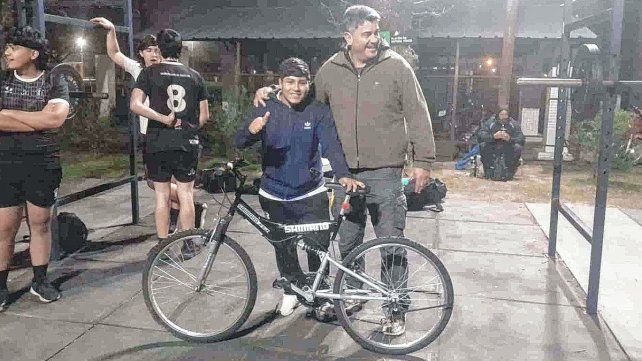 El entrenador Gonzalo Montes junto a Bautista y su bicicleta que recuperó por la solidaridad de todos.