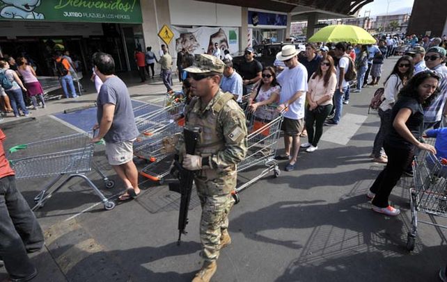 Colas. Residentes de Iquique deben esperar por horas para comprar alimentos. Un bidón de agua cuesta  200 dólares.