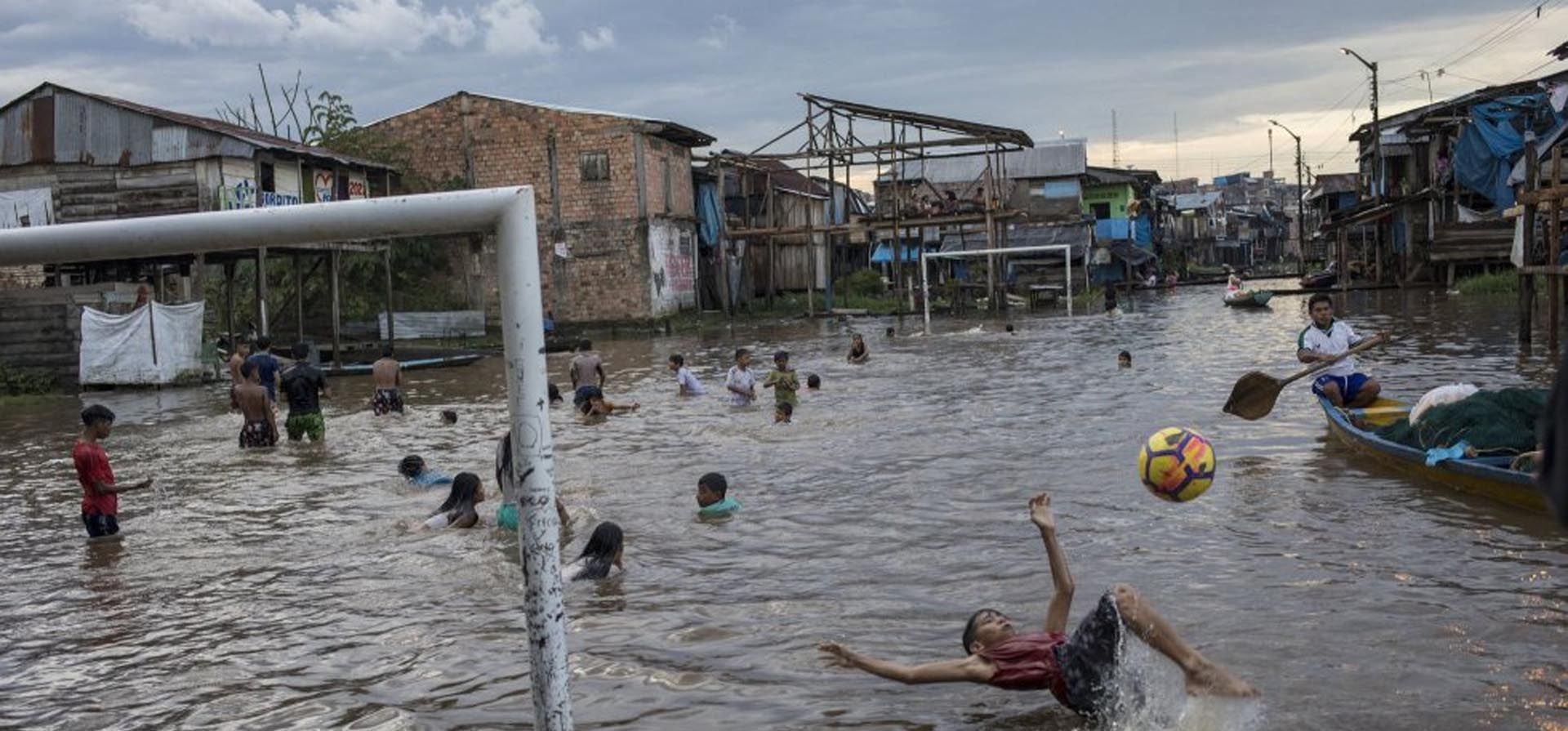 Niños juegan en un área inundada de la comunidad de Belén en Iquitos, Perú, el 20 de marzo de 2021. Históricas lluvias dejaron la zona bajo una gran inundación por al menos 15 días. Foto: AP