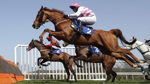 Magic Dancer montado por Richard Patrick salta una valla durante el evento Watch On RacingTV Handicap Hurdle en el hipódromo de Ludlow, Inglaterra. Las carreras de caballos todavía se llevan a cabo, pero sin la multitud de personas que asistian antes de la pandemia.