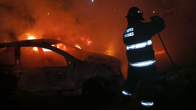 Bomberos Zapadores trabajan sobre uno de los autos incendiados frente a la seccional 32ª.&nbsp;