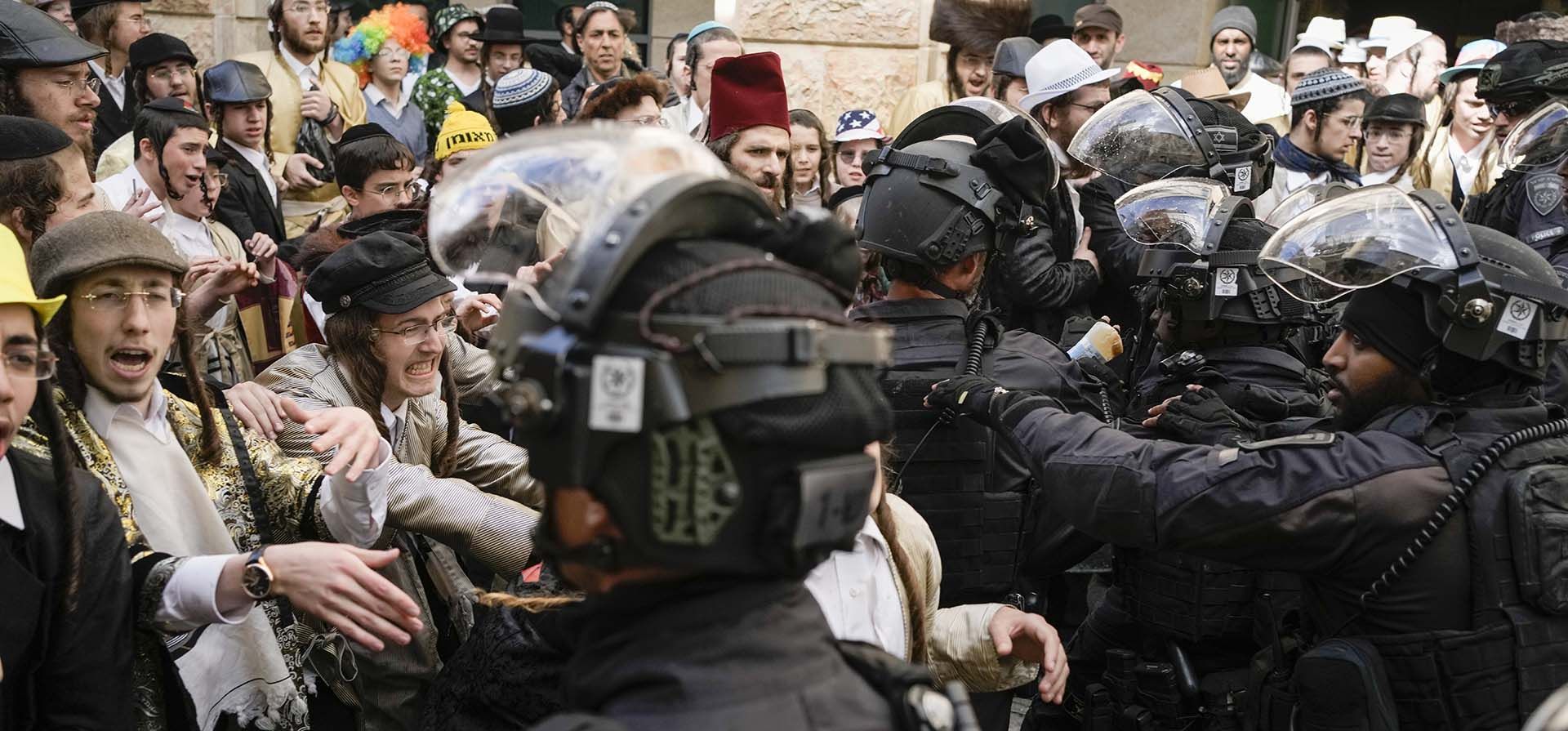 Policías se pelean con hombres y niños judíos ultraortodoxos, algunos disfrazados, durante la festividad judía de Purim en el barrio ultraortodoxo de Mea Shearim en Jerusalén el lunes 25 de marzo de 2024. (Foto AP/Ohad Zwigenberg) Policías se pelean con hombres y niños judíos ultraortodoxos, algunos disfrazados, durante la festividad judía de Purim en el barrio ultraortodoxo de Mea Shearim en Jerusalén el lunes 25 de marzo de 2024. (Foto AP/Ohad Zwigenberg)