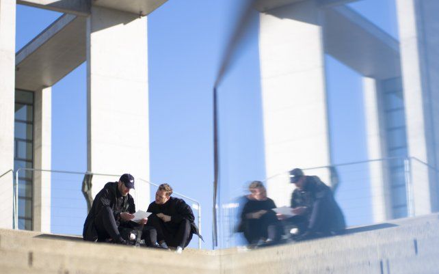 Dos hombres tomar un descanso al sol en el distrito gubernamental de Berlín, Alemania.