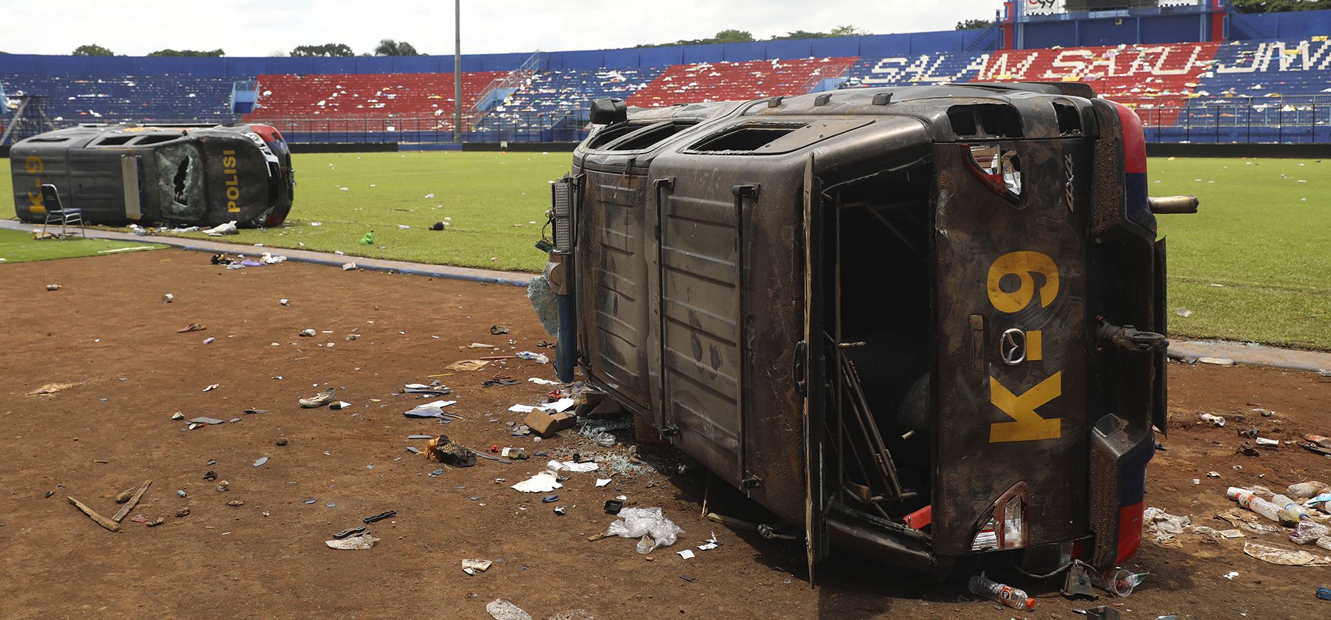 Coches de policía destrozados en la cancha del estadio Kanjuruhan en Malang, Java Oriental, Indonesia, el domingo 2 de octubre de 2022. El pánico en un partido de fútbol de Indonesia el sábado dejó más de 100 muertos, la mayoría de los cuales fueron pisoteados después de que la policía disparó gases lacrimógenos para disipar disturbios.