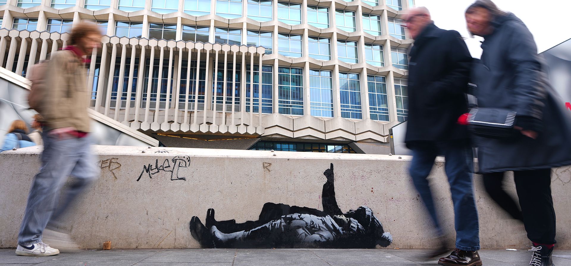 Peatones pasan junto a un grafiti que representa a dos personas, afuera de la estación Tottenham Court Road en Londres, el lunes 22 de diciembre de 2025. (Foto AP/Kirsty Wigglesworth) Peatones pasan junto a un grafiti que representa a dos personas, afuera de la estación Tottenham Court Road en Londres, el lunes 22 de diciembre de 2025. (Foto AP/Kirsty Wigglesworth)