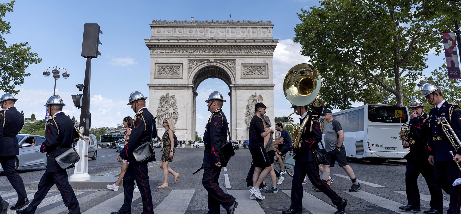 Músicos de una banda de la brigada de bomberos cruzan la calle para actuar en una ceremonia en el Arco de Triunfo antes de los Juegos Olímpicos de Verano de 2024, el sábado 20 de julio de 2024, en París. (Foto AP/David Goldman) Músicos de una banda de la brigada de bomberos cruzan la calle para actuar en una ceremonia en el Arco de Triunfo antes de los Juegos Olímpicos de Verano de 2024, el sábado 20 de julio de 2024, en París. (Foto AP/David Goldman)