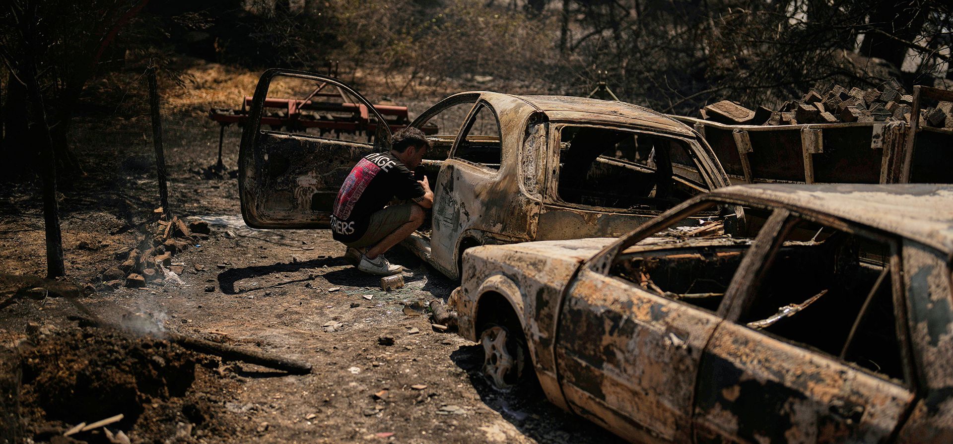 Un hombre revisa un coche quemado tras un incendio en Guzelyali, a las afueras de Canakkale, en el noroeste de Turquía, el martes 12 de agosto de 2025. (Foto AP/Khalil Hamra) Un hombre revisa un coche quemado tras un incendio en Guzelyali, a las afueras de Canakkale, en el noroeste de Turquía, el martes 12 de agosto de 2025. (Foto AP/Khalil Hamra)