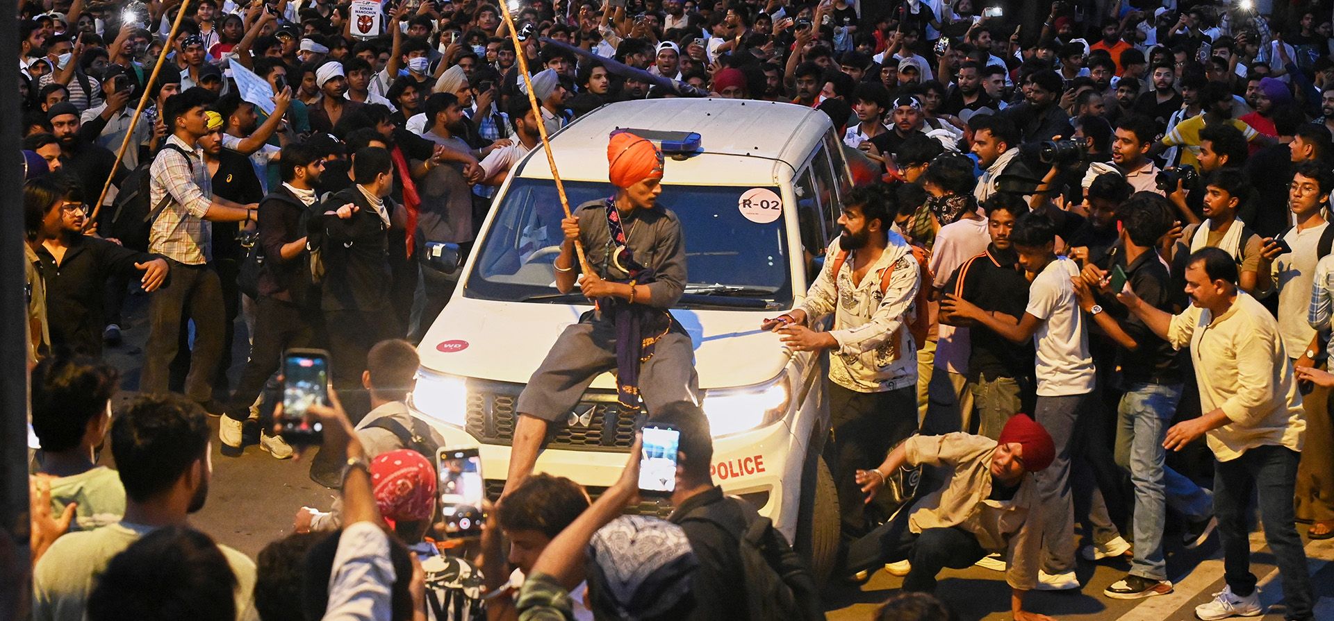 Un manifestante, sentado sobre un auto policial durante una manifestación para reclamar reformas educativas como parte de la protesta del movimiento del Partido de las Cucarachas en Nueva Delhi, India, el 22 de julio de 2026. (AP Foto/Vipin) Un manifestante, sentado sobre un auto policial durante una manifestación para reclamar reformas educativas como parte de la protesta del movimiento del Partido de las Cucarachas en Nueva Delhi, India, el 22 de julio de 2026. (AP Foto/Vipin)