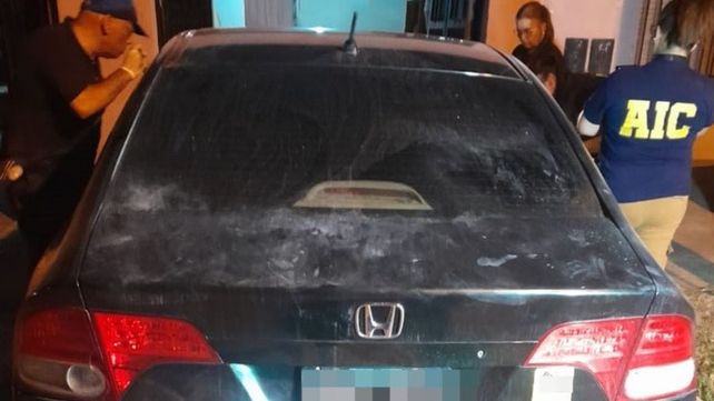 Personal de la AIC revisa el Honda Civic negro hallado en una vivienda de barrio Godoy.