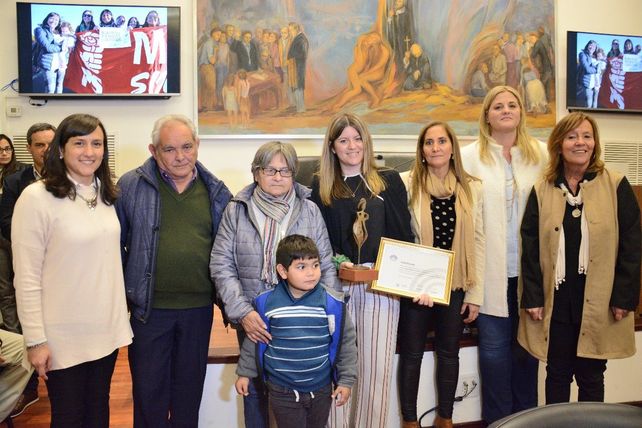 En el medio sosteniendo el premio