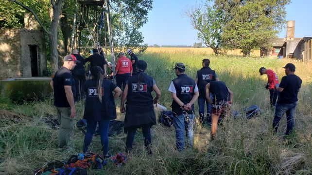 Peritajes. Bomberos y policías junto al viejo molino en desuso en cuyo pozo se encontró el cadáver mutilado.