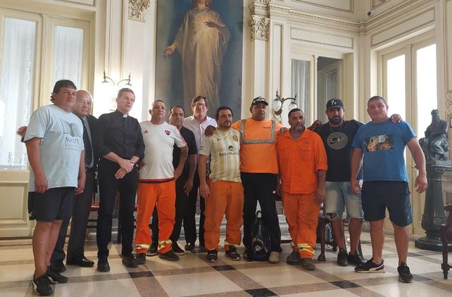 Miembros de la Iglesia de Rosario junto a un grupo de trabajadores del puerto local.